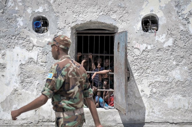 Prisoners at Mogadishu Central Prison watch as a guard walks pass their cell in December 2013. Most of the military court’s hearings in Mogadishu take place inside the prison, which limits access to hearings for relatives and independent monitors.
© Tobin Jones
